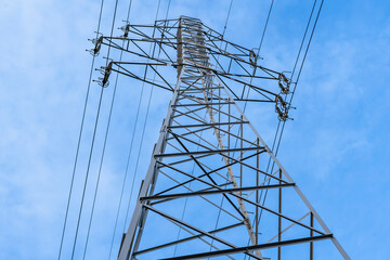 Electric station for supplying electricity to city, village. High voltage electric tower. Close-up. Power line against blue sky.