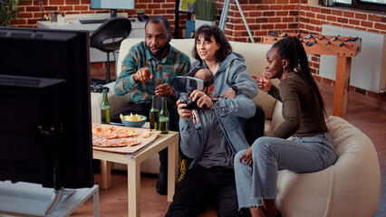 Wall Mural - Cheerful people having fun with vr glasses and tv console, playing video games with 3d simulation and virtual reality headset. Enjoying home gathering with beer bottles, online gameplay.