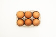 Half a dozen brown eggs in a container or egg cup viewed from the top