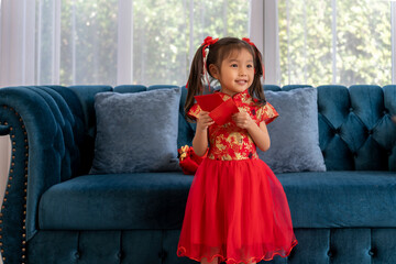 Wall Mural - Portrait little girl wearing chinese traditional costumes sitting on couch