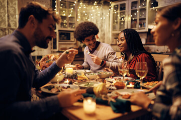 Wall Mural - Happy black woman enjoys in Thanksgiving dinner with friends in dining room.