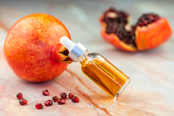 Wall Mural - Pomegranate oil in a cosmetic bottle with a pipette. 