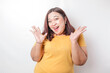 A portrait of a shocked big sized Asian woman wearing a yellow t-shirt, isolated by a white background