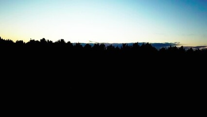 Wall Mural - Aerial Panning Silhouette Of Trees On Mountain Against Sky At Sunset - Cable, Wisconsin