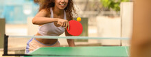 African-American Woman Playing Ping Pong With Friend Outdoors. Banner Design
