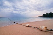 Bouys On The Rope Marker On The Sandy Beach. Beautiful Seascape With Cloudy Sky.