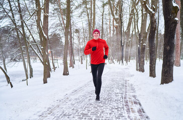 Healthy lifestyle. Jogging outdoors. Young strong man is running at snowy park.