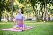 © bongkarn - Relaxed Asian woman in sportswear practicing half pigeon yoga pose on her yoga mat