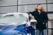 © Petro - Young man standing by car covered with snow