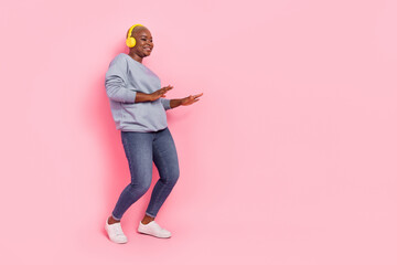 Wall Mural - Full length photo of cheerful girl enjoy listen music dance empty space isolated on pink color background