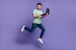 © deagreez - Full length photo of positive man buy modern quality gadget device apple macbook move go empty space isolated on purple color background
