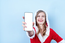 Closeup Of Caucasian Happy Woman Wearing Santa Clothes Pointing At The Smartphone