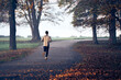© baranq - Back view of man running in park at autumn morning