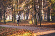 © baranq - Man running in park during sunny autumn morning