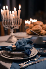 Wall Mural - Food for Hanukkah celebration: Menorah Candles on wooden table, sufganiyot cake and table setting, jewish symbol centerpieces, white and blue. holiday Israel hebrew traditional family celebration