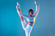 © Georgii - Beautiful flexible girl dancing lifting her leg up. Isolated figure of sporty girl in white sports uniform on blue background.