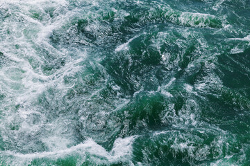 Wall Mural - Stormy ocean water with waves and foam, top view, texture