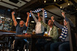 © BalanceFormCreative - Senior football and soccer fans drinking beer at the pub, cheering and celebrating scores.