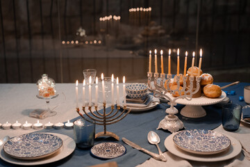 Wall Mural - Food for Hanukkah celebration: Menorah Candles on wooden table, sufganiyot cake and table setting, jewish symbol centerpieces, white and blue. holiday Israel hebrew traditional family celebration