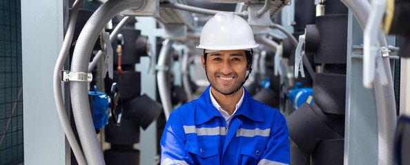 Looking at camera and smiling. Portrait handsome confident professional engineer man wearing safety uniform and hard hat helmet in industrial factory workplace