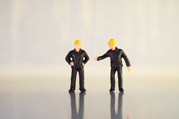 Miniature people, couple engineers in black suits standing alone using as industry and business concept
