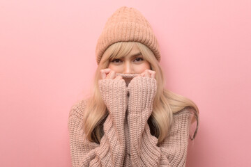 Wall Mural - Portrait of Caucasian young woman wearing sweater over pink background