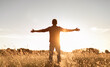 © kieferpix - Having a positive mindset, wellbeing and hope concept. Happy young man standing in a nature sunrise field with arms outstretched.