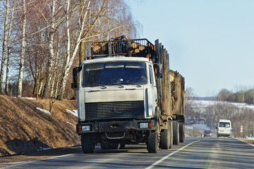 Wall Mural - Heavy loaded timber truck with trailer drive on the country road at spring day . Front view