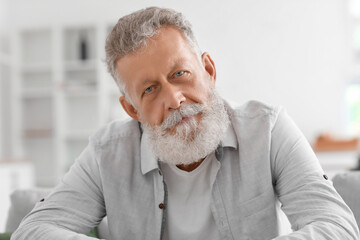 Sticker - Senior bearded man sitting on sofa in kitchen, closeup