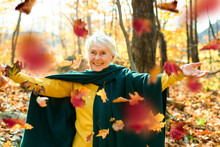 Happy Elderly Senior Woman In An Autumn Park.
