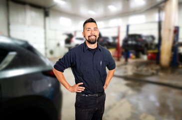 Wall Mural - Handsome mechanic job in uniform working on car