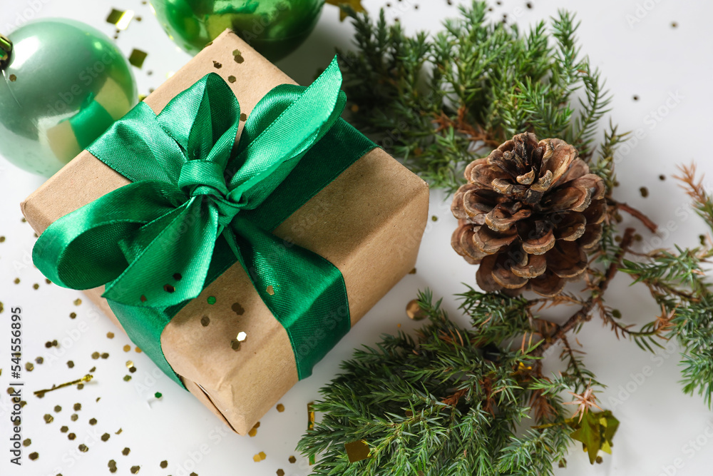 Beautiful Christmas gift and fir branches on white background, closeup