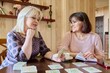 © Valerii Honcharuk - Two middle aged women laying out cards at home on the table