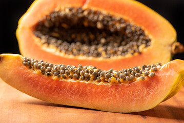 Wall Mural - Papaya, details of a sliced ​​papaya over rustic wood, selective focus.