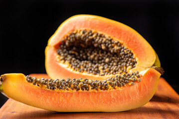 Wall Mural - Papaya, details of a sliced ​​papaya over rustic wood, selective focus.