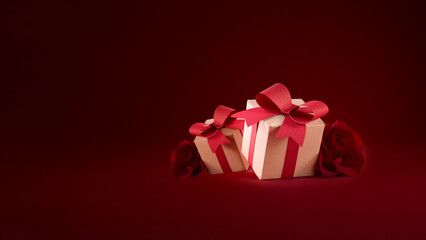 Paper art Valentine's day concept banner with hand made gift box, paper cut ribbon, bow, and a lot of hearts on a red background with space for text.