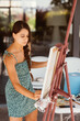 © teksomolika - Young woman artist paints with a spatula on the canvas