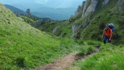 Canvas Print - White Caucasian man hiking on the rocky Ciucas mountain in Romania