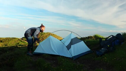 Canvas Print - Caucasian man making a tent on a mountain in Ciucas Romania