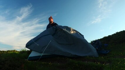 Canvas Print - Caucasian man making a tent on a mountain in Ciucas Romania