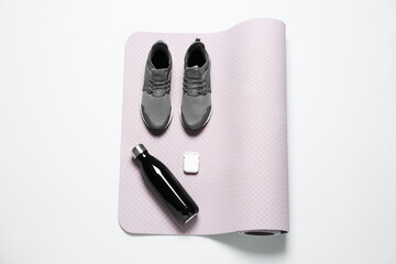 Poster - Exercise mat, bottle of water, wireless earphones and shoes on light grey background, top view