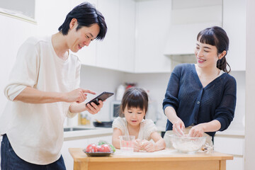 Wall Mural - レシピを調べながら料理をするファミリー