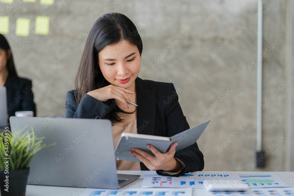 Asian businesswoman working on finance and business information at the ...
