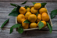 Overhead View Of A Box Of Tangerines On A Wooden Table