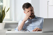 © New Africa - Man suffering from eyestrain at desk in office