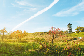 Wall Mural - Watchtower on the green meadow on a sunny day.Autumn landscape.