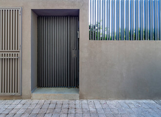 Wall Mural - A modern house entrance, with a grey door and fence wall by the sidewalk. Athens, Greece.