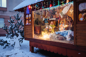 Wall Mural - Christmas crib at a Cologne Christmas market. The scene where the Virgin Mary gave birth to Jesus and he lies in the cradle surrounded by people who have come to celebrate the Nativity of Christ