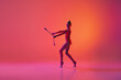 Studio shot of young charming girl, rhythmic gymnast training with sports equipment isolated over pink background in neon light filter