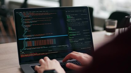 close up of freelancer's hands typing code on laptop keyboard. camera slides around developer's fige